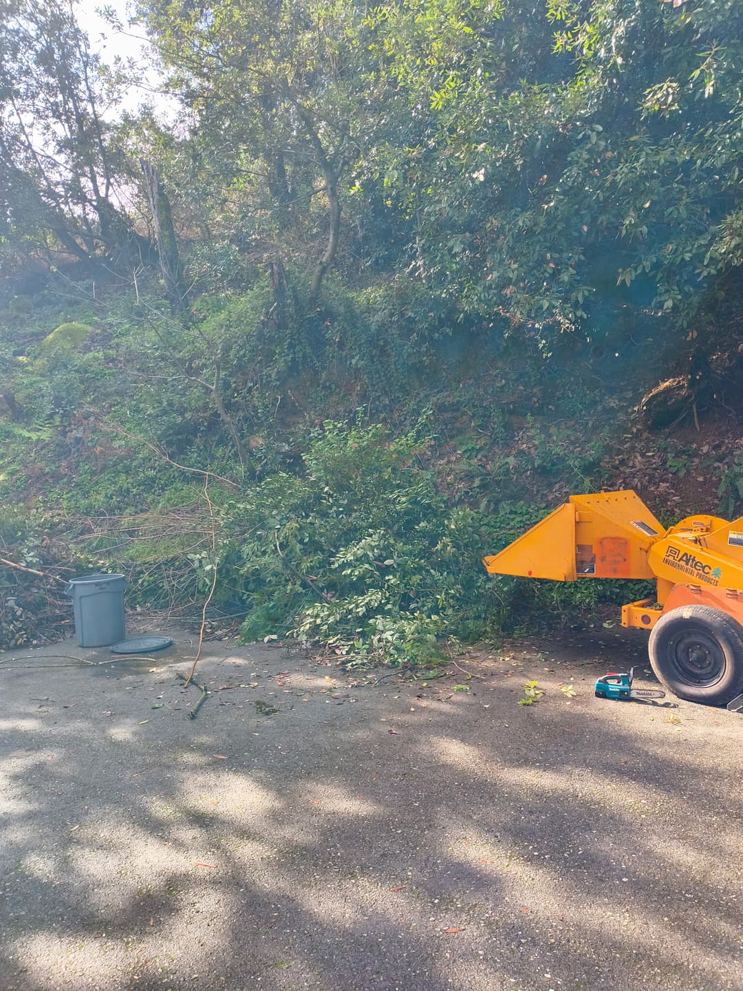 Altec wood chipper parked on steep hillside driveway ready for tree branch chipping service